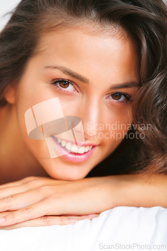 Image of Woman, portrait and smile for lying on bed, relax and smile for lazy face or rest in apartment. Happy female person, wake up and satisfaction for bedding, comfortable and closeup for bedtime in home