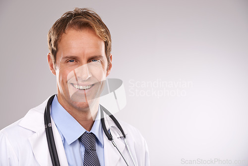 Image of Man, doctor and smile in studio, portrait and medical professional on gray background. Male person, healthcare and pride for cardiologist career, physician and trustworthy specialist for medicare