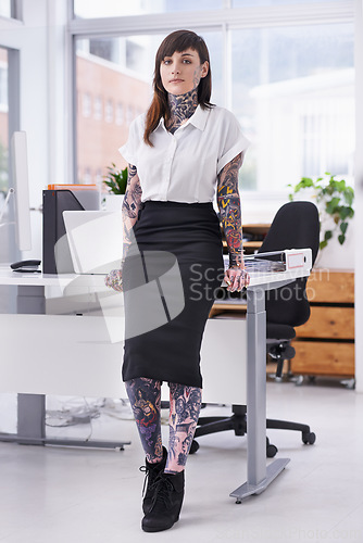 Image of Tattoos, portrait and business woman in office with positive, good and confident attitude. Grunge, pride and professional edgy female creative designer with ink skin standing in modern workplace.