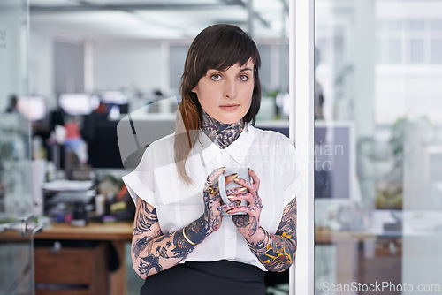 Image of Tattoos, coffee and portrait of business woman in office with positive, good and confident. Grunge, cappuccino and professional edgy creative designer with ink skin standing in modern workplace.