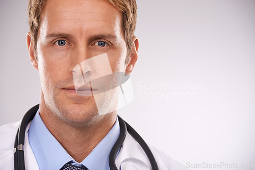 Image of Doctor, man and portrait in studio for health, medic or diagnosis with stethoscope for job on mockup. Young person or expert and serious and confident for career, medicine and specialist for medical