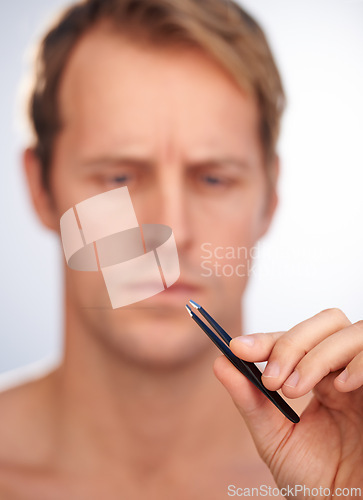 Image of Man, hand and tweezers or beauty grooming in studio or hair removal treatment, transformation or skincare. Male person, tool and wellness routine on white background or hygiene, cleaning or cosmetic