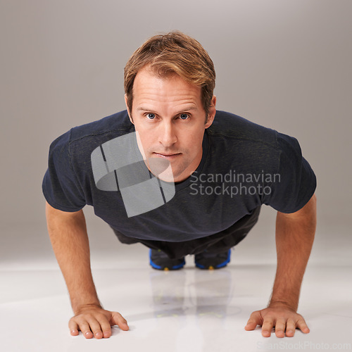 Image of Fitness, man and portrait in studio for push up, workout and exercise for wellness, health and diet. Young person and active for cardio, strength and gym for strong and fit on floor for sport