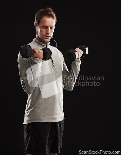 Image of Man, dumbbells and weightlifting training in studio or fitness performance, workout or black background. Male person, equipment and earphones for music playlist or healthy, streaming or mockup space