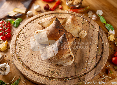 Image of Delicious calzones on a wooden board