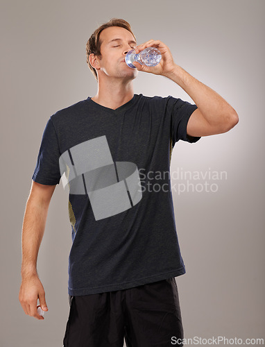 Image of Healthy, studio or man drinking water for fitness, hydration or workout break isolated on grey background. Tired person, training or thirsty athlete with fresh h2o liquid drink for exercise or detox