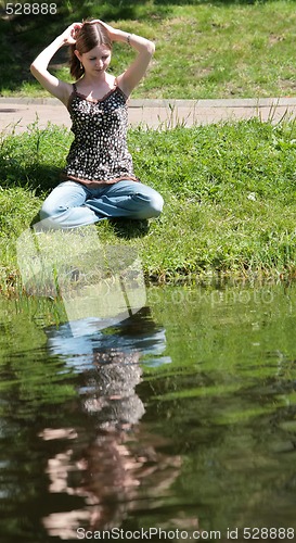 Image of girl sits near lake