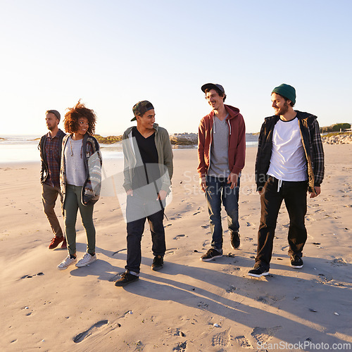 Image of Sand, sunset and group of friends at beach for vacation adventure, support and bonding together in Miami. Nature, summer and people by ocean for holiday, travel or weekend trip for peace at seaside