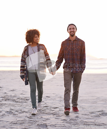 Image of Couple, smile and walking together on beach, happy calm people on vacation. Ocean, outdoor and partners in love with respect and care, date and romantic stroll for relax with seaside sunrise
