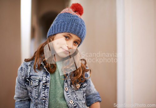 Image of Girl, portrait and child with fashion in winter at home with pride and happiness in clothes with hat. Kid, smile or relax in house with beanie, jacket or casual style on holiday or vacation in Sweden