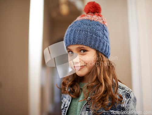 Image of Girl, portrait and child with fashion in winter at home with pride and happiness in clothes with hat. Kid, smile or relax in house with beanie, jacket or casual style on holiday or vacation in Sweden