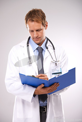 Image of Clipboard, writing and doctor in studio for medical report, insurance and research for hospital. Healthcare, clinic and worker with documents for consulting, wellness and planning on gray background