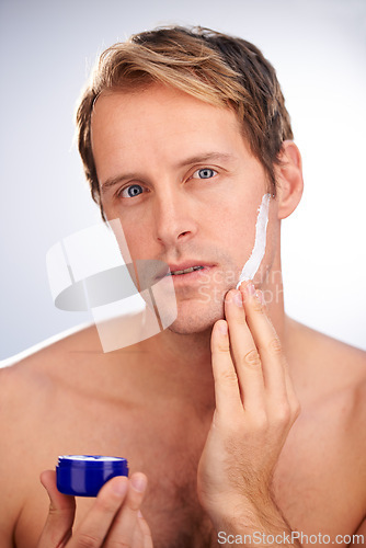 Image of Man, portrait and skincare cream or product for moisturiser routine or dermatology, transformation or studio. Male person, face and wellness as hygiene lotion for facial, white background or mockup