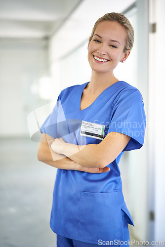 Image of Happy woman, portrait and nurse with confidence in career ambition for healthcare or science at hospital. Young female person, scrub or medical doctor with smile or arms crossed for PHD at the clinic