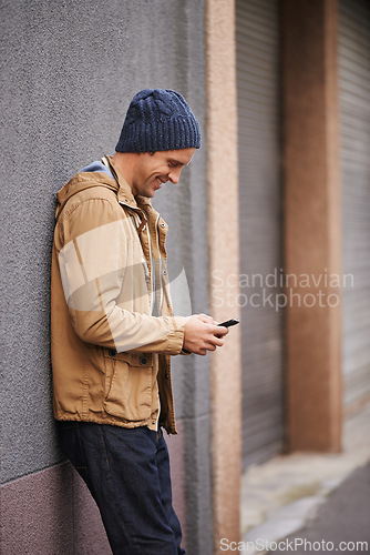 Image of Happy, typing and man in city with phone for social media, networking and online text message in street. Travel, weekend and person on cellphone for website, internet search and chat in urban town