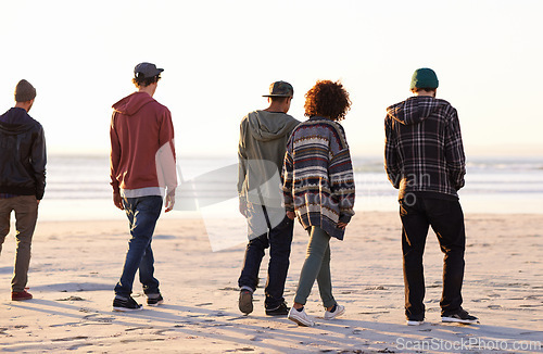 Image of Friends, walking and beach for sunset, sand and sea with ocean for nature, behind and peace outdoor. Young people or group together for trek and environment for summer season and warm vacation