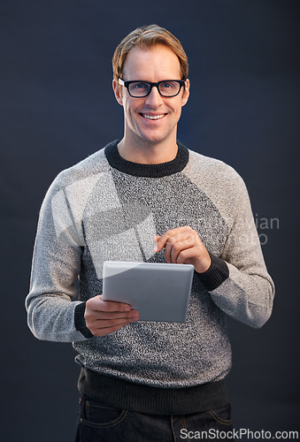 Image of Man, glasses and tablet in studio with smile for portrait, connection or contact by dark background. Person, entrepreneur or geek with digital touchscreen, pride or fashion with app for social media