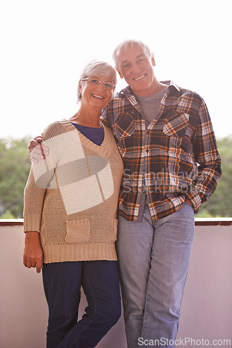 Image of Senior couple, smile and portrait on balcony with hug, love and outdoor with connection for retirement. Elderly woman, old man and embrace on patio with pride, care and happy at apartment in Germany