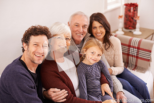 Image of Grandparents, parents and kid on sofa for portrait with hug, care or love with generations for bonding in home. Mother, father and senior people with child for embrace on lounge couch in family house