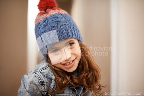 Image of Girl, portrait and child with fashion in winter at home with pride and confidence in clothes with beanie. Kid, smile or relax in house with hat, jacket or casual style on holiday or vacation