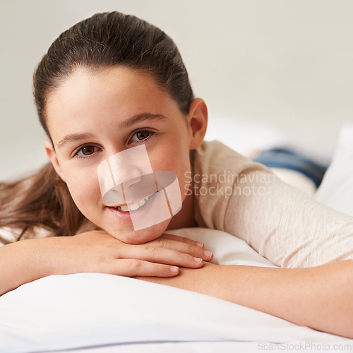 Image of Girl, relax and smile on bed in home, wellness and peace or calm for waking up on weekend. Female person, pillow and comfortable in bedroom for rest or happy, blanket and lazy on vacation or holiday