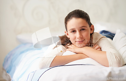 Image of Girl, relax and portrait on bed in home, wellness and peace or calm for waking up on weekend. Happy female person, pillow and comfortable in bedroom for rest or smile, blanket and lazy in apartment