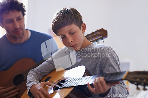 Image of Learning, guitar and child with teacher for music, lesson and development of skill with instrument. Playing, practice and man helping kid in education as musician mentor in acoustic sound on strings