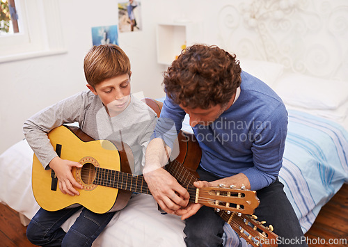 Image of Guitar, teacher and learning music with child in lesson for development of skill on instrument. Playing, practice and man helping musician kid in education with advice as mentor in acoustic sound