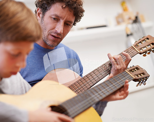 Image of Learning, guitar and teacher in music with child in lesson and development of skill on instrument. Playing, practice and man helping kid in education with advice as musician mentor in acoustic sound
