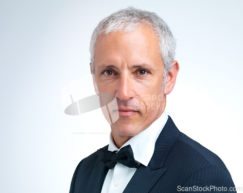 Image of Portrait, mature man and tuxedo in studio with confidence, designer fashion and stylish in white background. Serious, elegant and male person with pride in suit, fancy and cool style in mockup space