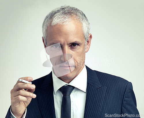 Image of Portrait, suit and mature man smoking cigarette with salesman in studio isolated on a gray background. Face, fashion and serious businessman with tobacco, ceo or manager in vintage clothes in Canada