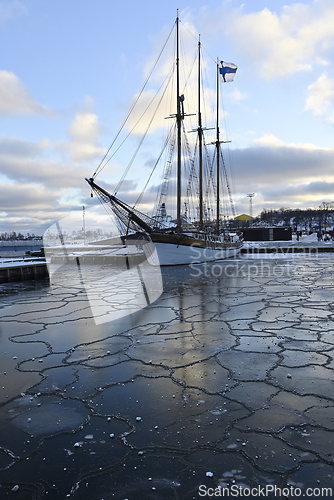 Image of sailing ship in the port of Helsinki with the Finnish flag on th