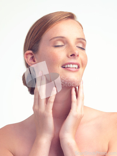 Image of Face, natural beauty and skincare of woman for glow, shine or health with eyes closed in studio isolated on a white background. Freckles, ginger model and touch skin with cosmetics for dermatology