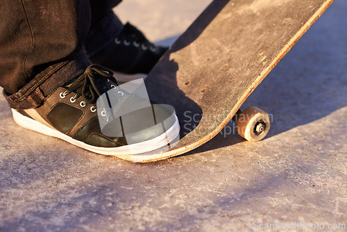 Image of Closeup, skateboard and person with sneakers, skill and training with technique or fitness. Skater, practice or athlete with energy, sunshine or performance with weekend break, shoes or skating style