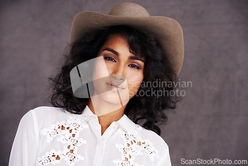 Image of Portrait, studio and woman with cowgirl fashion, confidence and relax with girl in stetson hat. Rodeo, western style and face Mexican model with cowboy culture, wild west clothes and grey background
