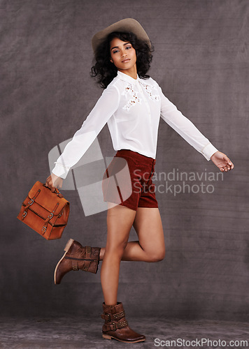 Image of Woman, fashion and country style in studio, trendy clothes and western boots for model. Native American, female person with bag accessory for countryside culture, confident or isolated on background