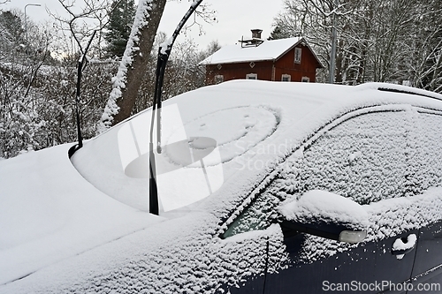 Image of A snow covered car with a smiley face on it