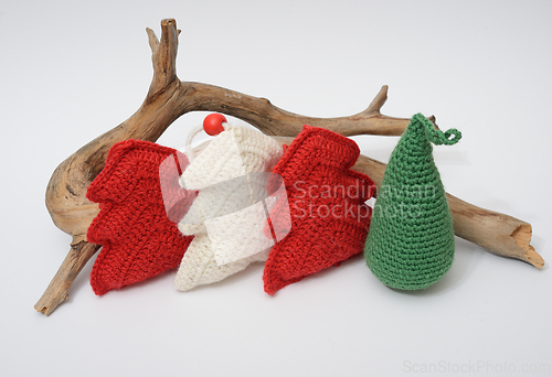 Image of A group of knitted christmas trees and a piece of wood