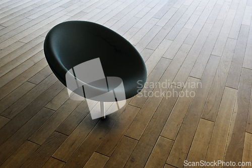 Image of A black chair on a wood floor