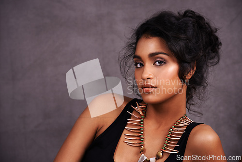 Image of Indian woman, confident and fashion with jewelry in studio on grey background for heritage or culture. Portrait, female person and beauty with traditional necklaces, outfit and heritage look.