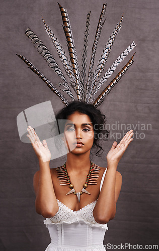 Image of Indian woman, fashion and feathers with jewelry in studio on black background for heritage or culture. Portrait, female person and confident with traditional necklaces or accessory and hands up