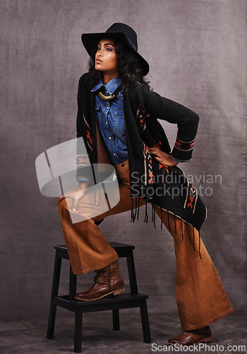 Image of Culture, cowgirl or woman thinking in studio, wild west and cool fashion or clothing on grey background. Native American person, western lady and stylish model with pride, boho style and chair stool