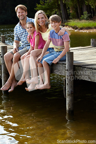 Image of Parents, lake and kids on pier for portrait, hug and happy on vacation, relax or love in summer sunshine. Mom, dad and children with smile, care or bonding with family by river on holiday in Colorado