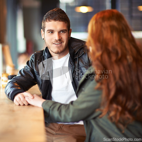 Image of Couple, hand holding and conversation in restaurant, romance and affection on date. Valentines day, sitting together with love for bonding, female person with boyfriend for trust and compassion