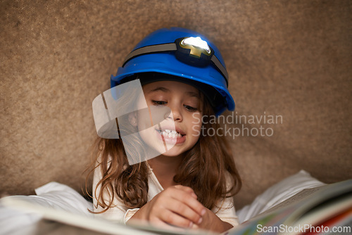 Image of Girl, child and book with headlamp for reading, above and learning with smile for education in family home. Kid, story and happy with light for info, language and literacy skills on floor in house