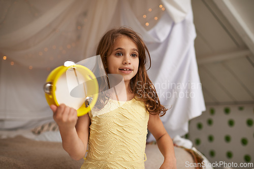 Image of Girl, child and happy in house with tambourine for playing, music and learning rhythm in bedroom. Kid, instrument and smile for noise, sound and concert for funny games with creativity at family home