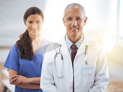 Image of Doctors, man and woman in portrait at hospital for medical support, wellness and arms crossed with smile. Medic, surgeon and nurse in team, happy and health services in clinic with pride for career