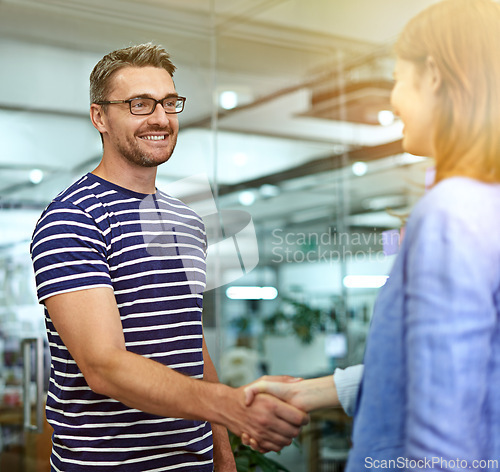 Image of Man, woman and handshake with smile at startup for welcome, introduction or onboarding with respect. Business people, shaking hands and happy for b2b deal, teamwork or thanks at creative media agency