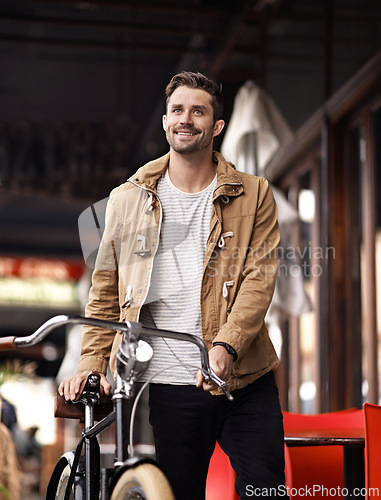 Image of City, commute and happy man with bicycle walking on sidewalk, smile and eco friendly transport. Carbon neutral, sustainability and tourist on urban journey, morning travel or male with bike on street