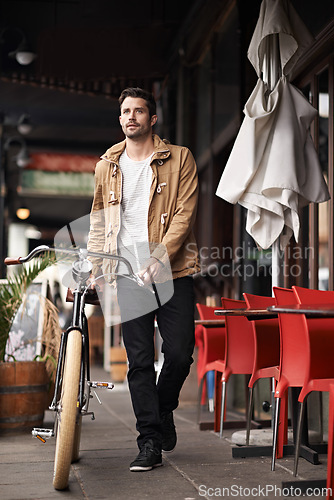 Image of Sidewalk, cafe and man with bicycle walking in city, thinking and eco friendly transport on commute. Carbon neutral, sustainability and tourist on street for urban journey, travel and male with bike